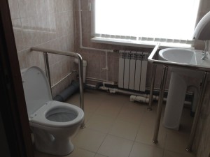 Туалет для людей с ограниченными возможностями оборудован поручнями