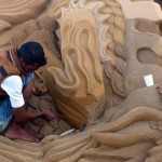 Песок увлажняют, чтобы форма держалась. Скульптор за работой