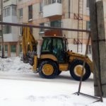 Трактор ждет самосвал, чтобы загрузить счищенный снег