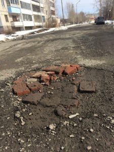 А это участок дороги по переулку Школьному. Потеряв надежду на ремонт, местные жители своими силами пытаются бороться с глубокими ямами.